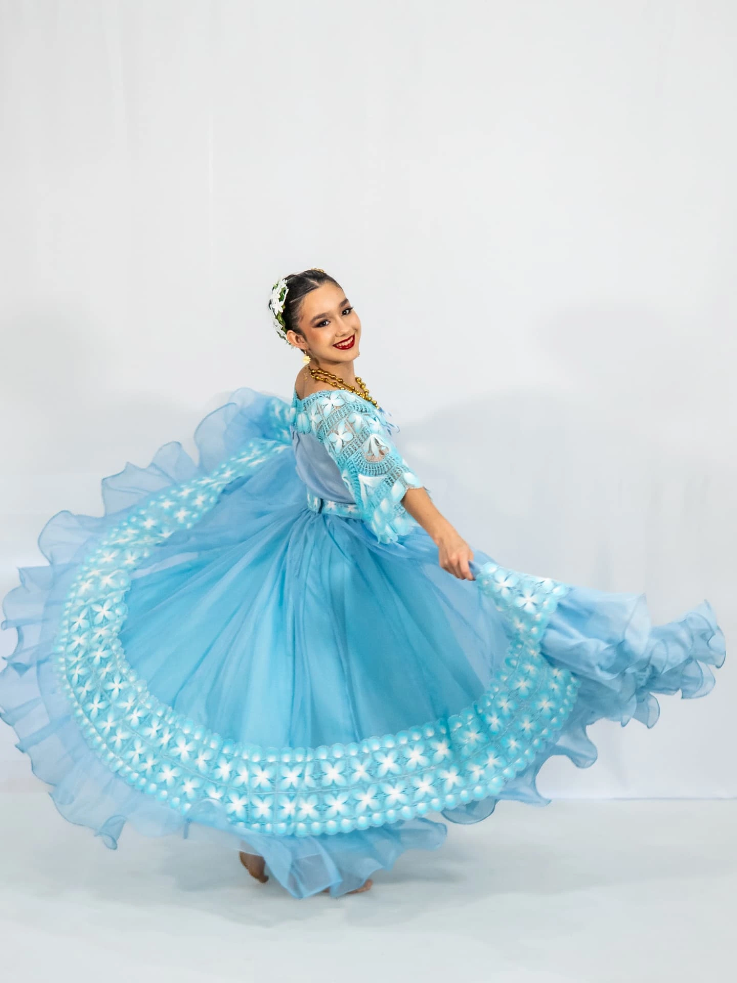Bailarina de DANZAR con vestido celeste de encaje paraguayo haciendo vuelo de falda
