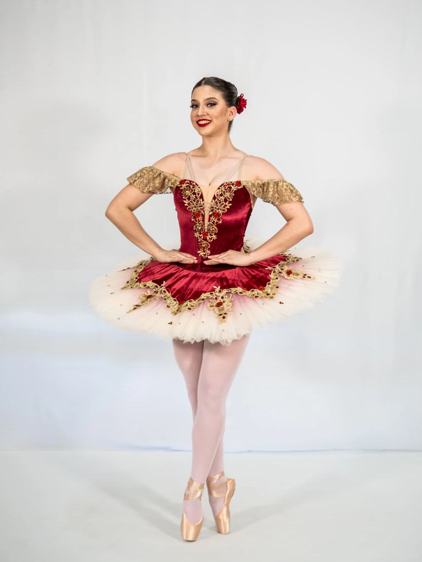 Bailarina de DANZAR en puntas con tutú rojo y dorado en estudio